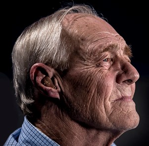 Old man with hearing aid Old man wearing a hearing aid
