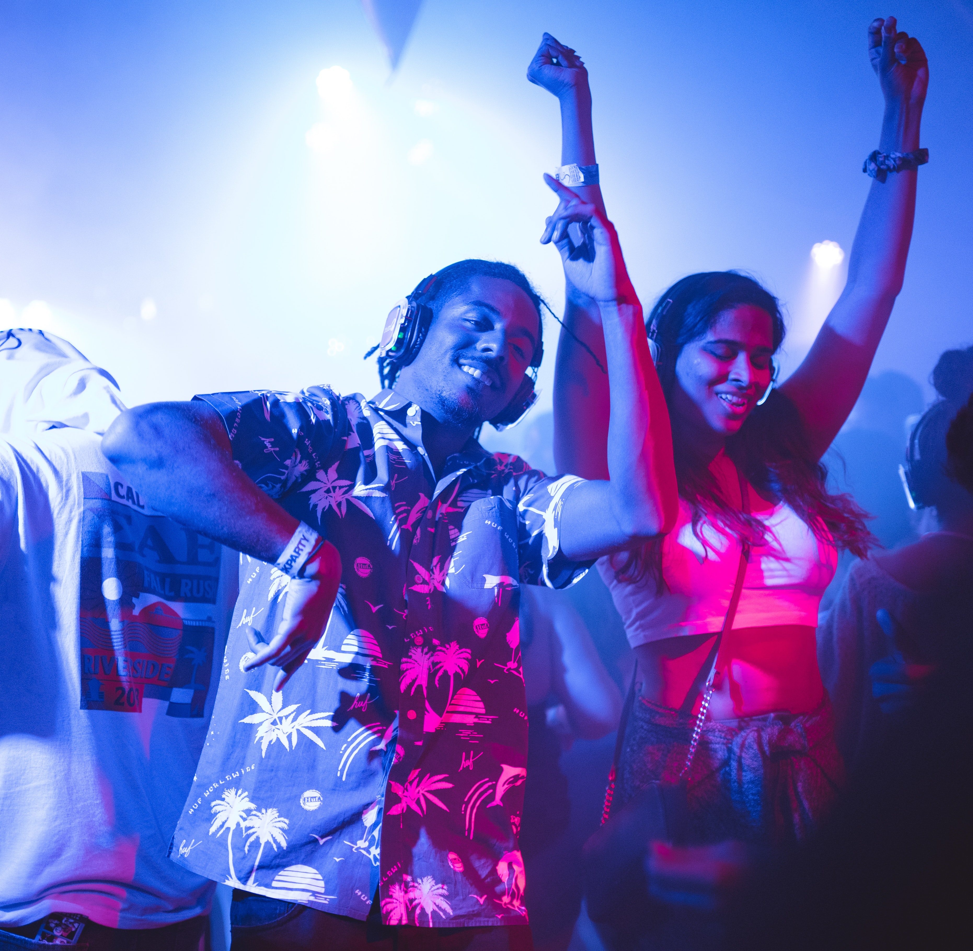A man and woman dancing at a concert Smiling Man Standing and Dancing Near Smiling Woman Surrounded With People