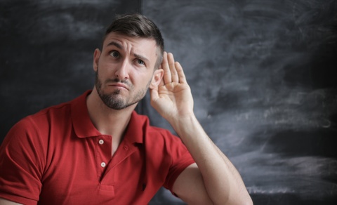 Man cupping ear to listen